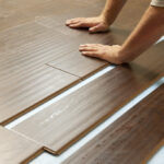 Man Installing New Laminate Wood Flooring Abstract.